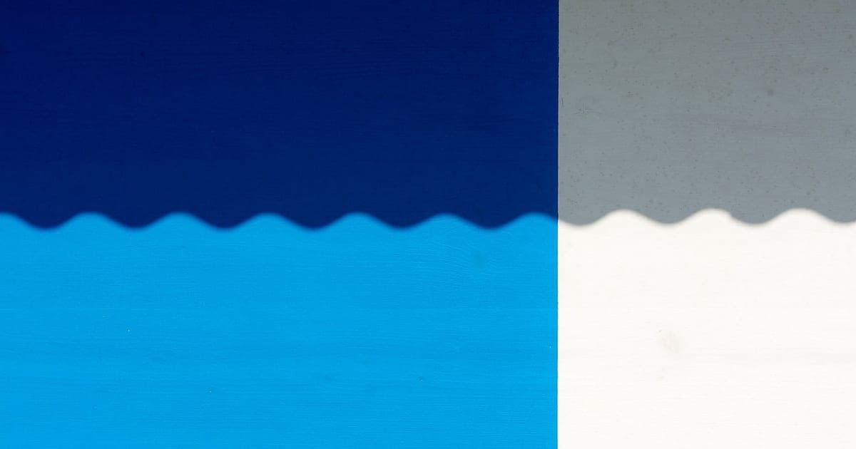 Two-tone blue and grey painted panels meeting at a scalloped edge